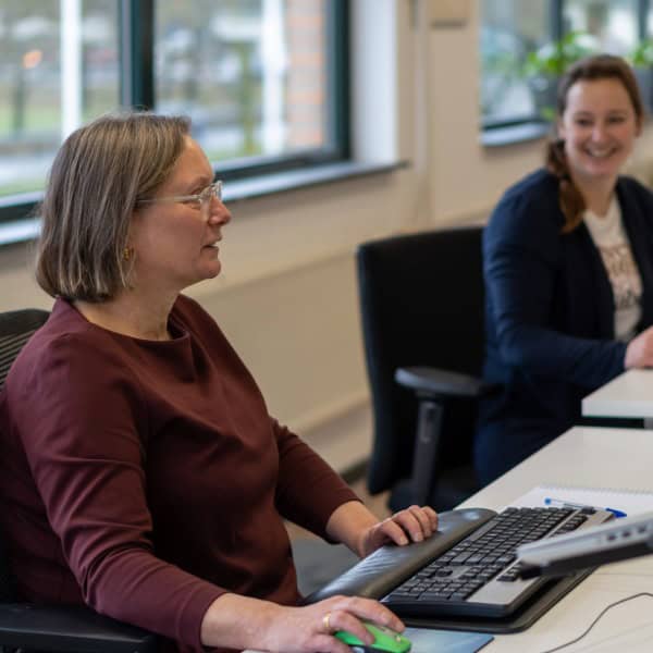 Vrouwelijke vertrouwenspersoon en medewerker in gesprek.